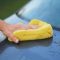 Car cleaning hacks shown by hand sponge at car back